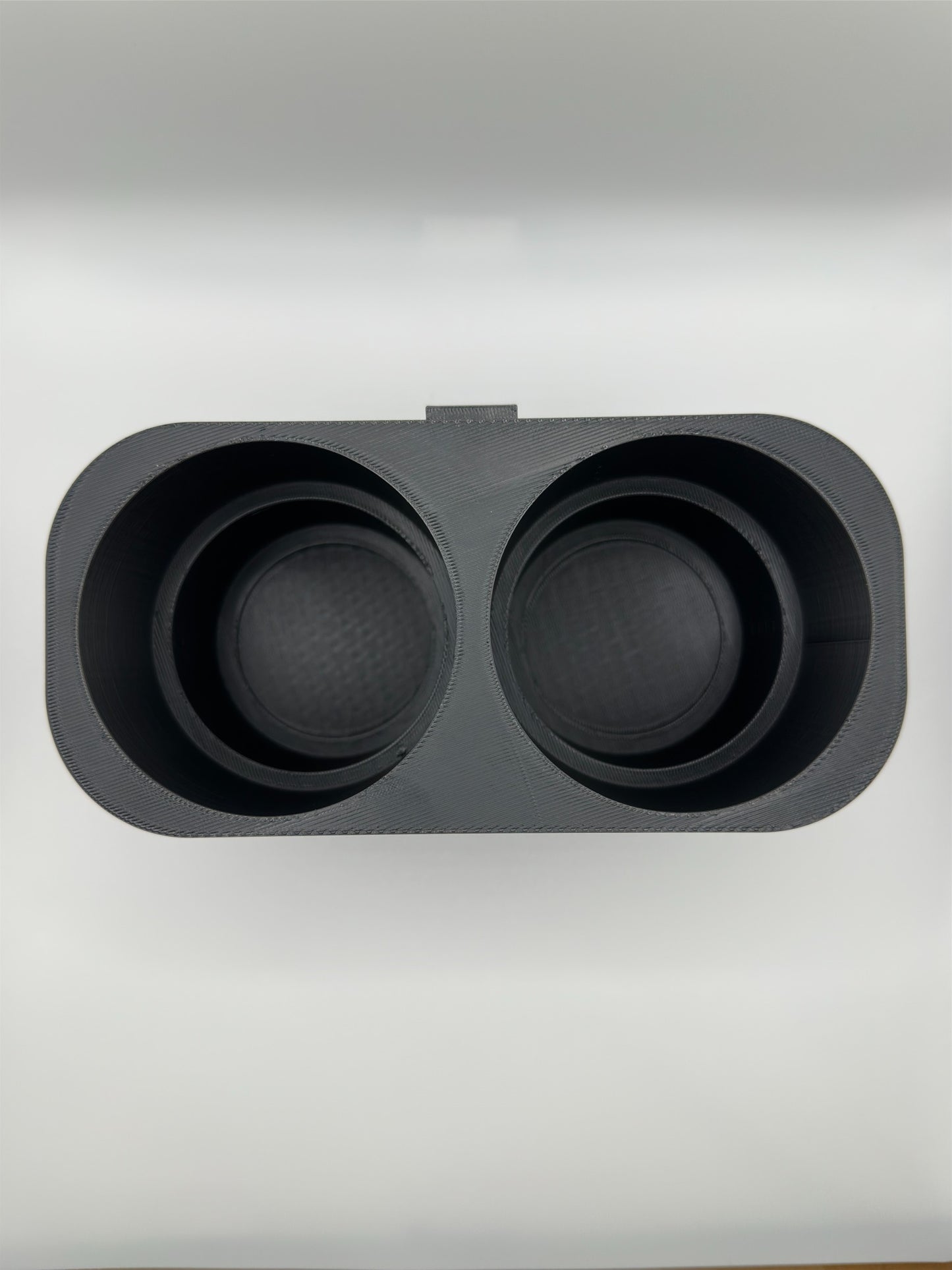 Bovenaanzicht van een 3D-geprinte dubbele bekerhouder in zwart, minimalistisch ontwerp.